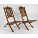 A pair of early 20th century doll caned folding chairs, 57 cm high Provenance: Contents of the