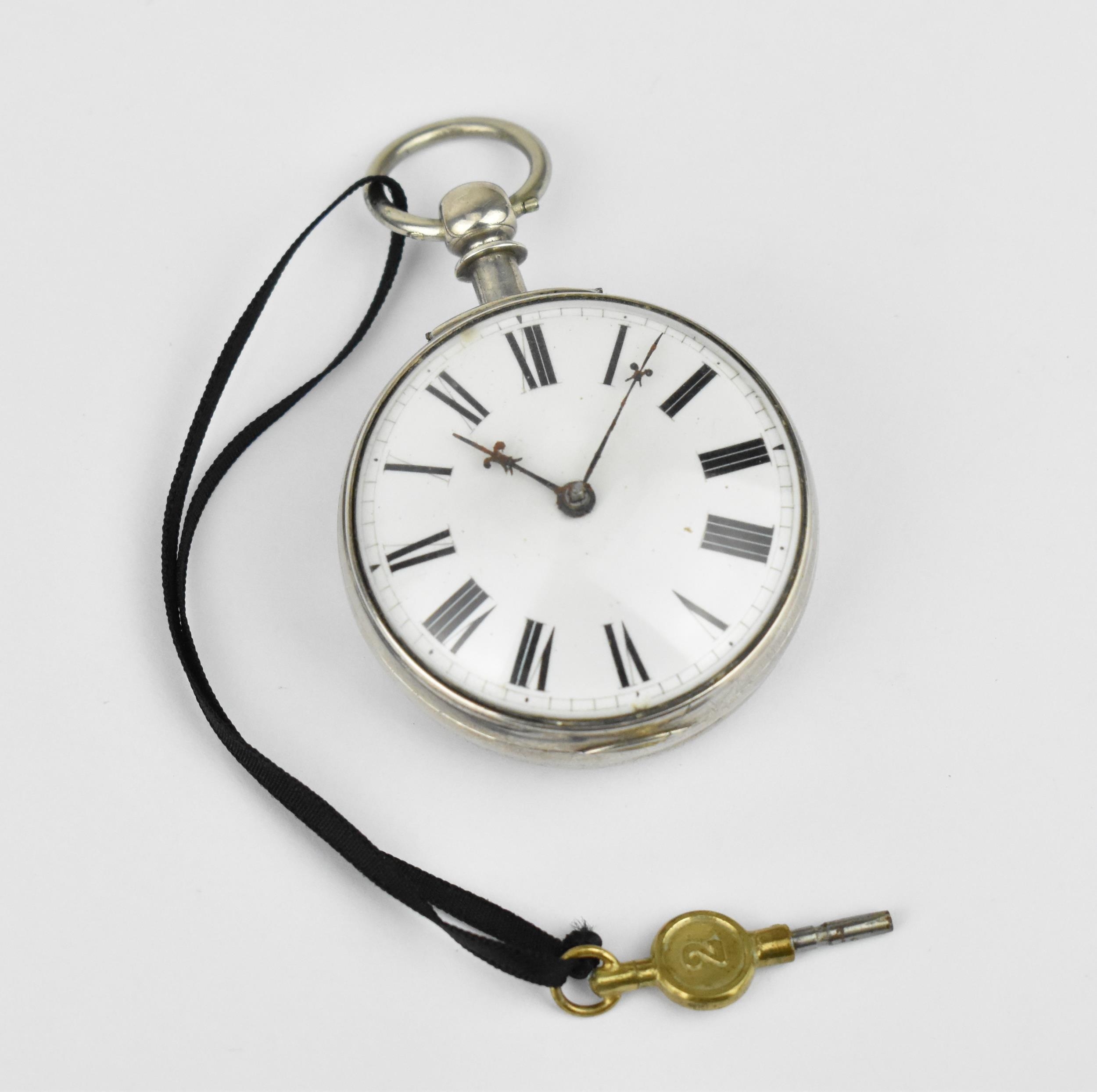 A Georgian and later silver open faced pocket watch having a white enamel dial, with fleur de lis