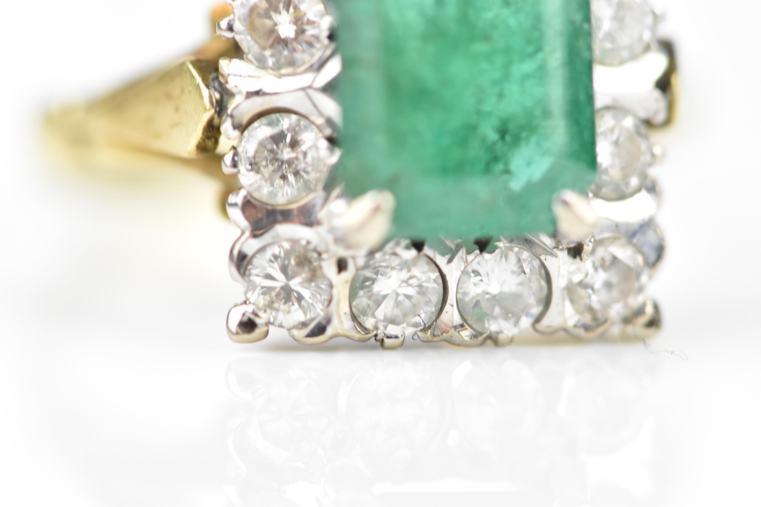 An 18ct yellow gold, emerald and diamond dress ring, with central step cut emerald in a halo of - Image 6 of 7