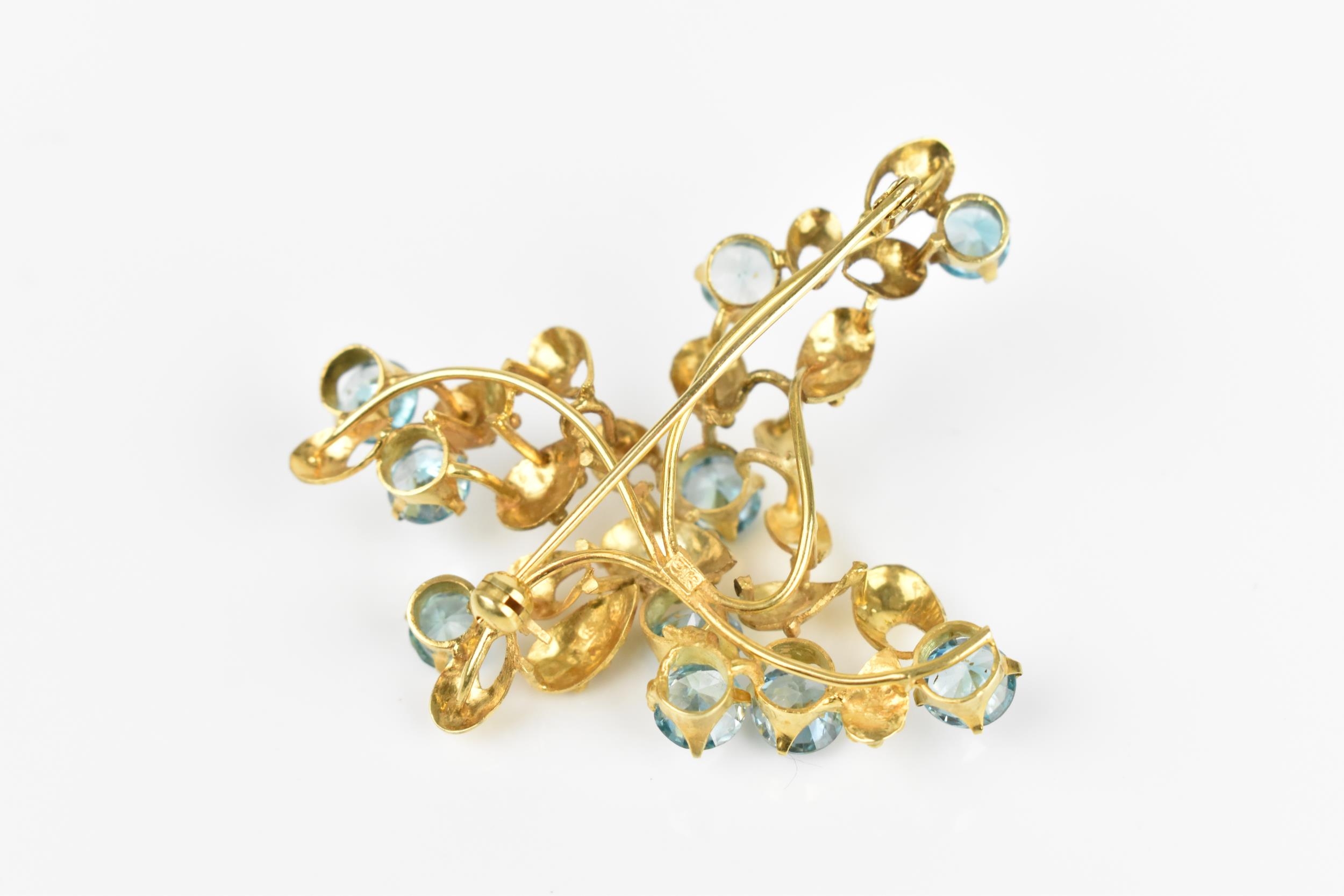 A 9ct yellow gold and blue stone floral brooch, modelled as a spray of foliage inset with round - Image 4 of 4