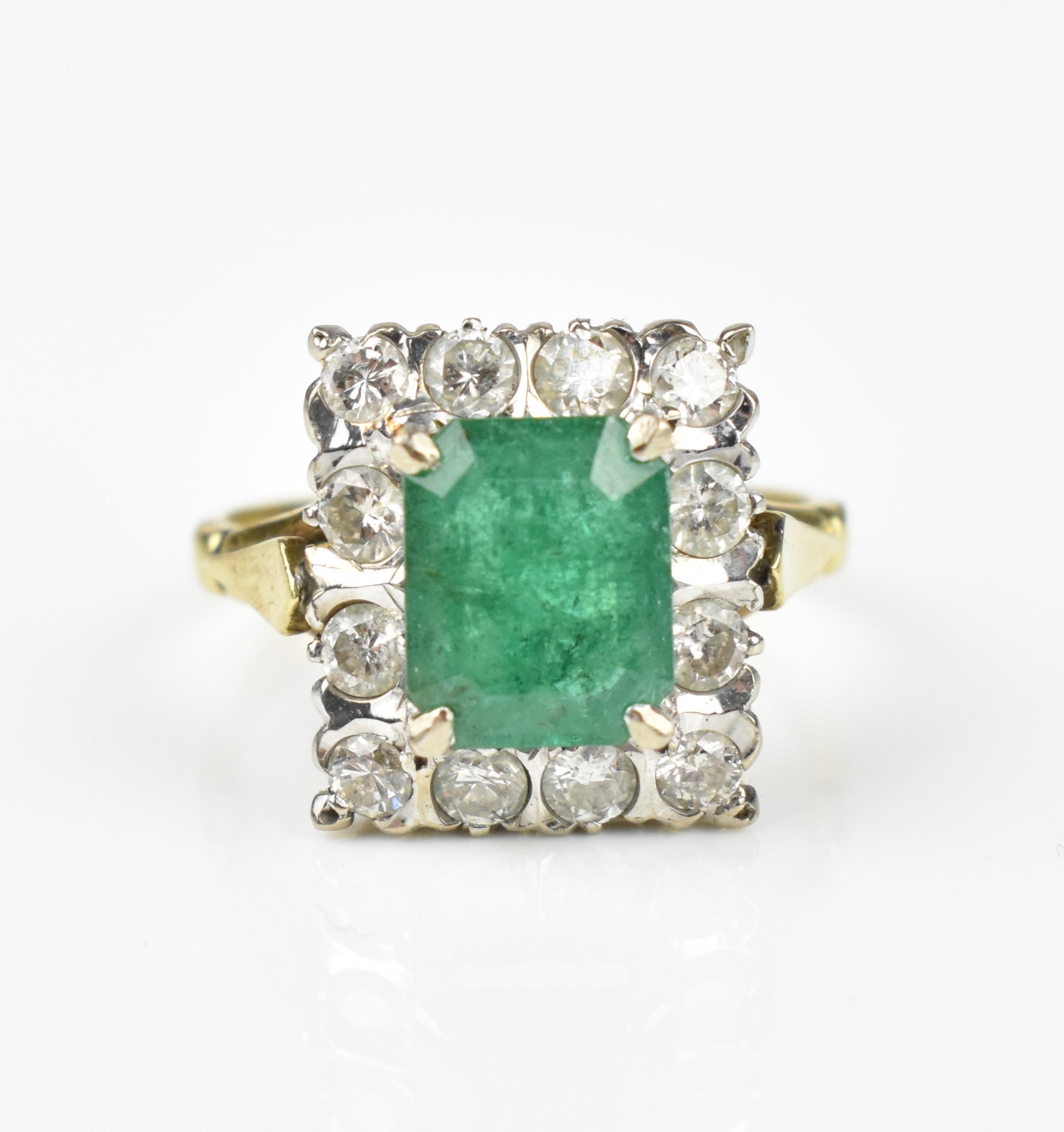 An 18ct yellow gold, emerald and diamond dress ring, with central step cut emerald in a halo of