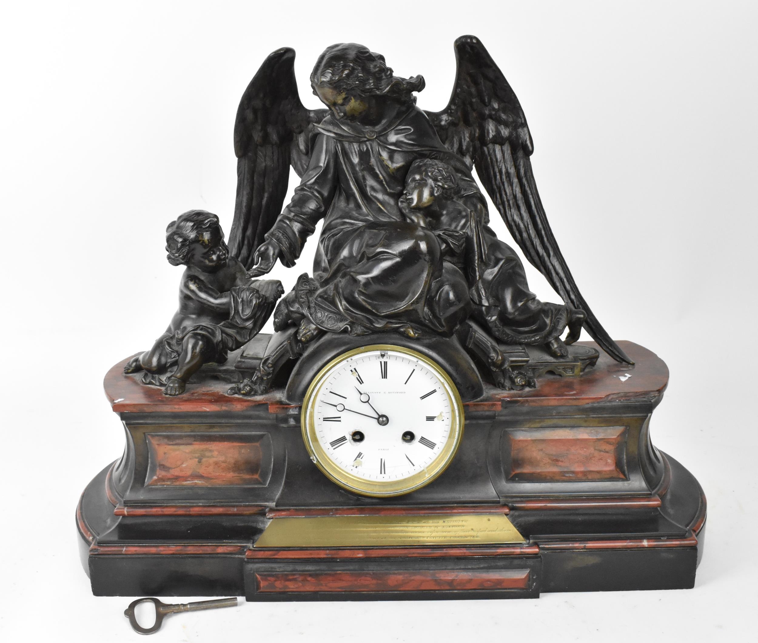 A 19th century French patinated bronze and marble figural mantle clock, the central enamel dial face
