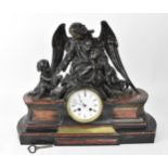 A 19th century French patinated bronze and marble figural mantle clock, the central enamel dial face