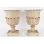 A pair of cast metal garden urns, with everted petal rim, part of the body with cast leaf, on a