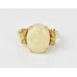 An 18ct yellow gold, opal and diamond dress ring, with central oval cabochon white opal flanked with