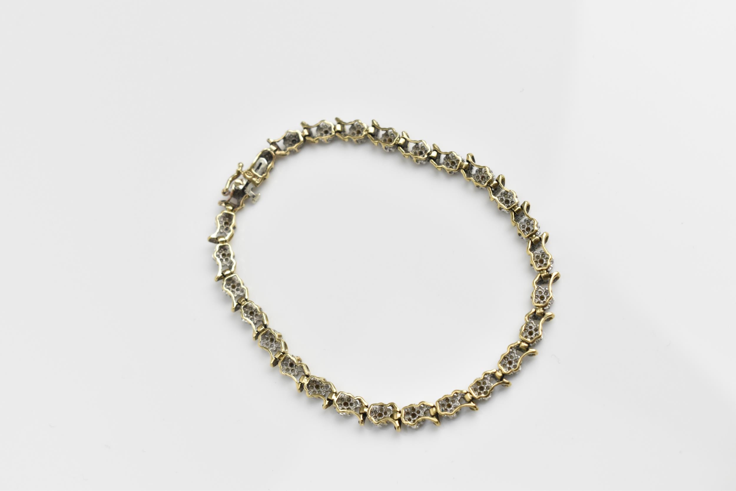 A 9ct yellow gold and diamond bracelet, designed with twenty-seven floral diamond clusters, with - Image 6 of 7