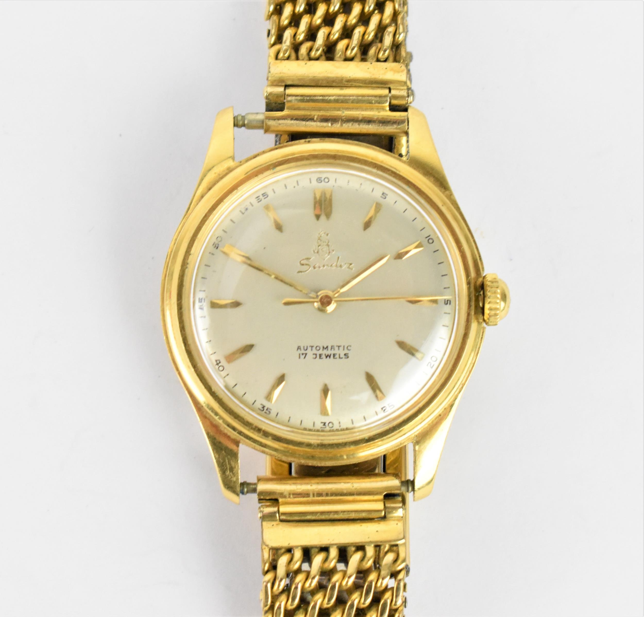 A Sandoz automatic, gents 18ct gold wristwatch, having a silvered dial with centre seconds and baton