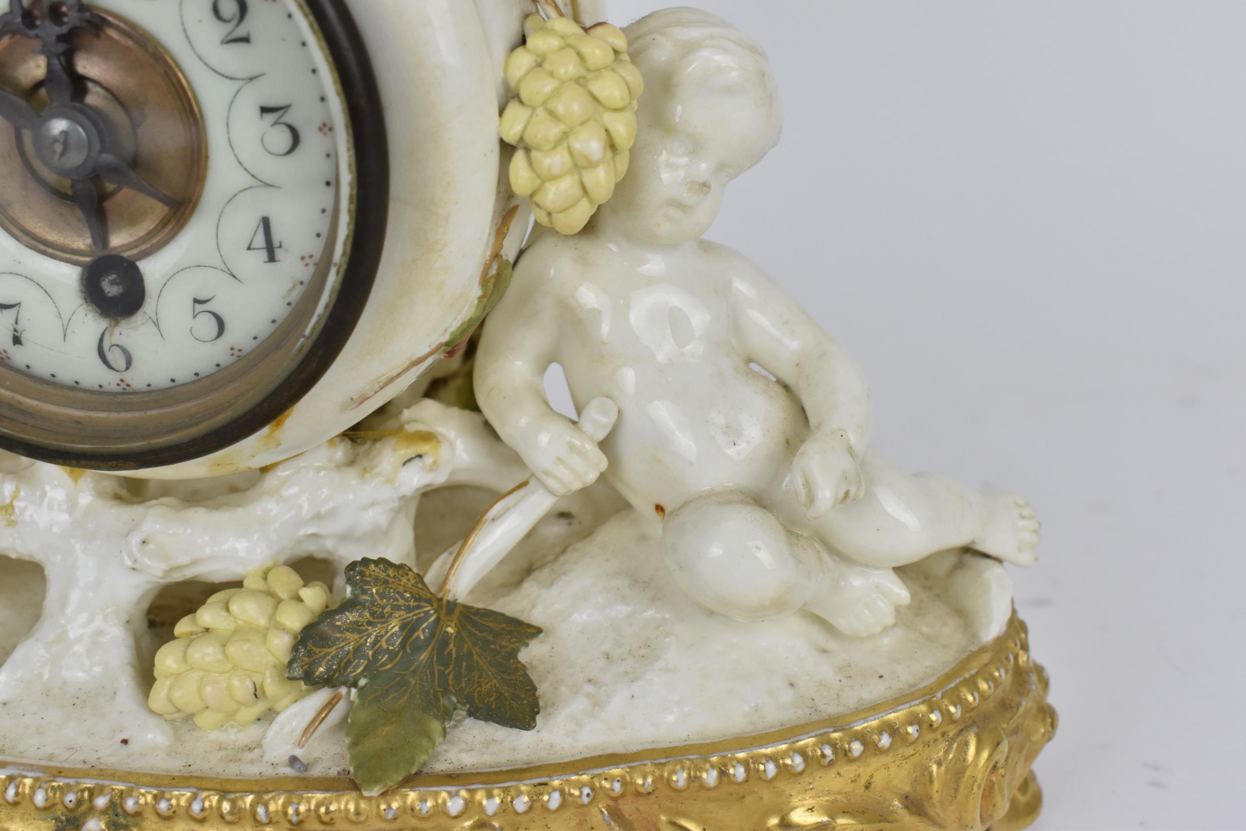 A late 19th century porcelain mantle clock, decorated with cherubs eating grapes on a gilded base, - Image 6 of 7