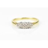 An 18ct yellow gold and three stone diamond ring, the three central stones with double prong white
