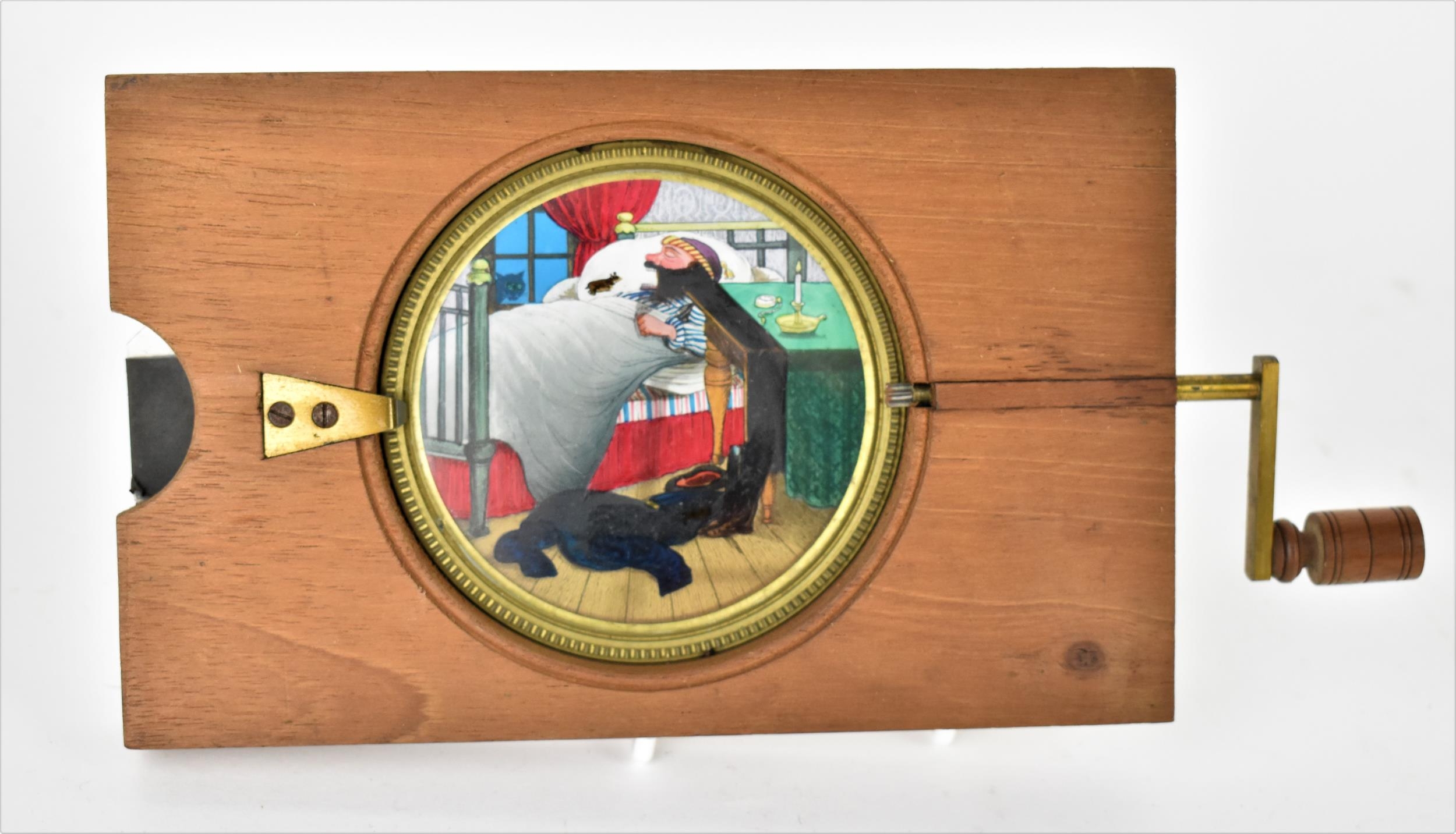 A Victorian mahogany-mounted hand painted rack and pinion magic lantern slide, depicting a