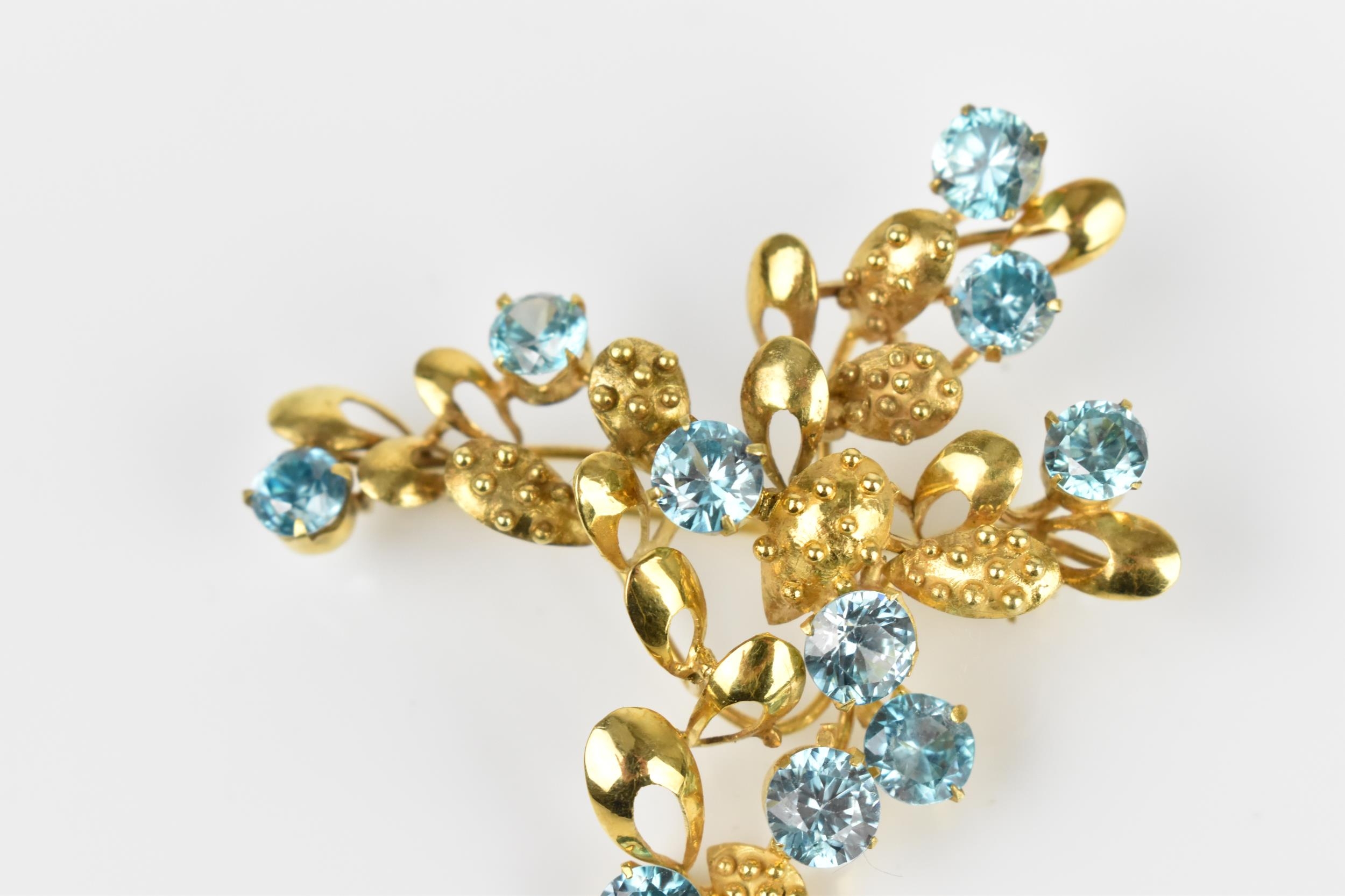 A 9ct yellow gold and blue stone floral brooch, modelled as a spray of foliage inset with round - Image 2 of 4