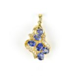 An 18ct yellow gold, diamond and sapphire pendant/brooch, inset with six cornflower blue sapphires
