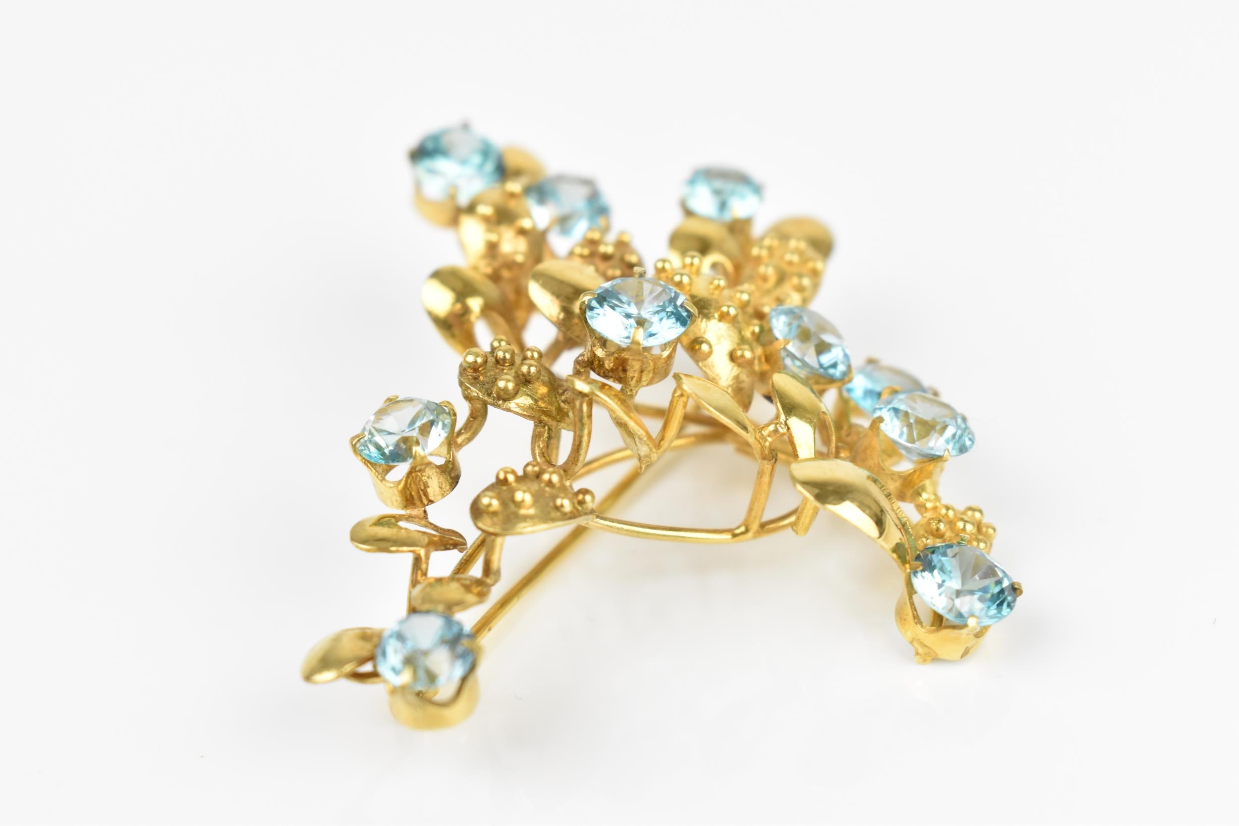 A 9ct yellow gold and blue stone floral brooch, modelled as a spray of foliage inset with round - Image 3 of 4