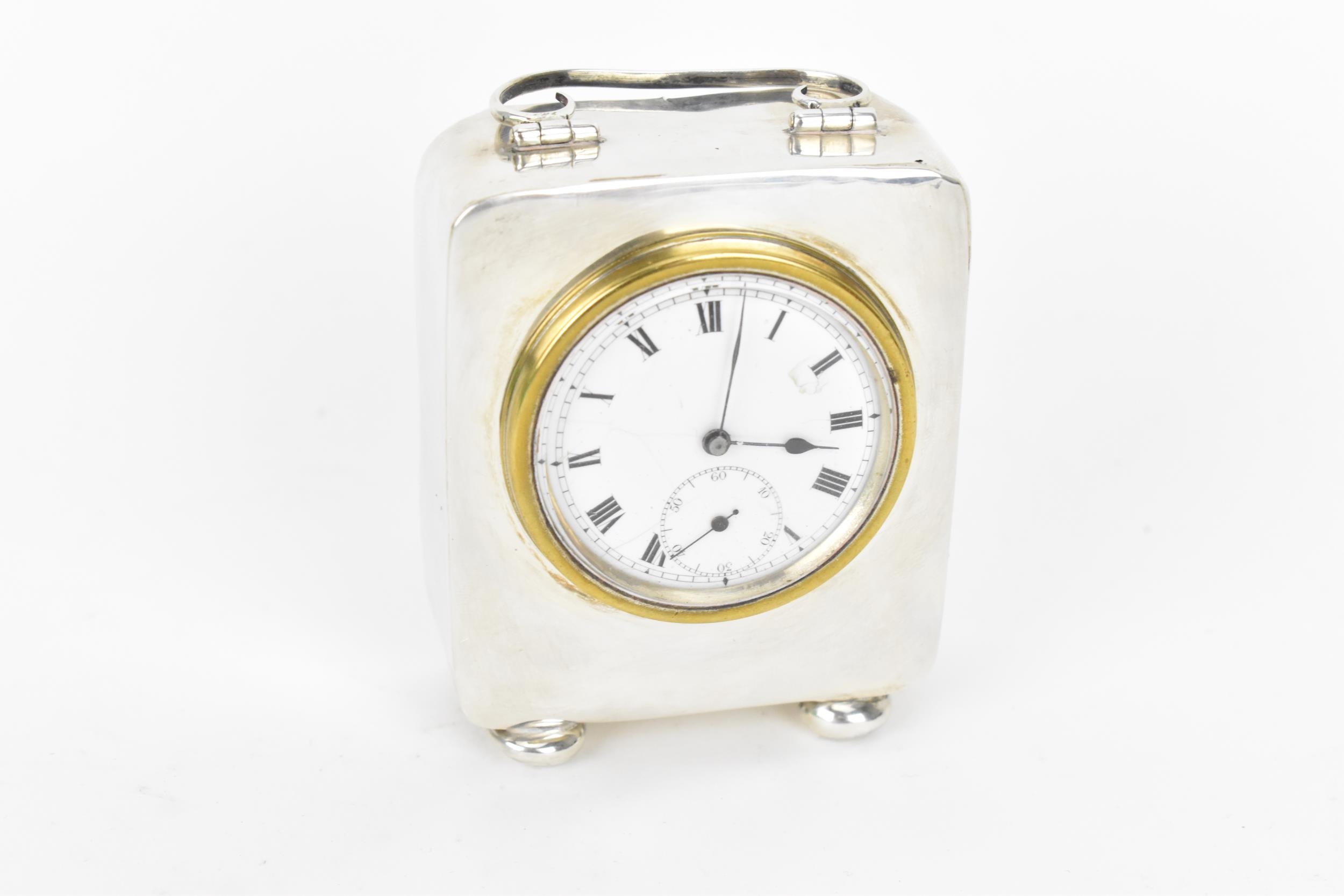 An early 20th century miniature silver cased carriage clock, the case having scroll handle with