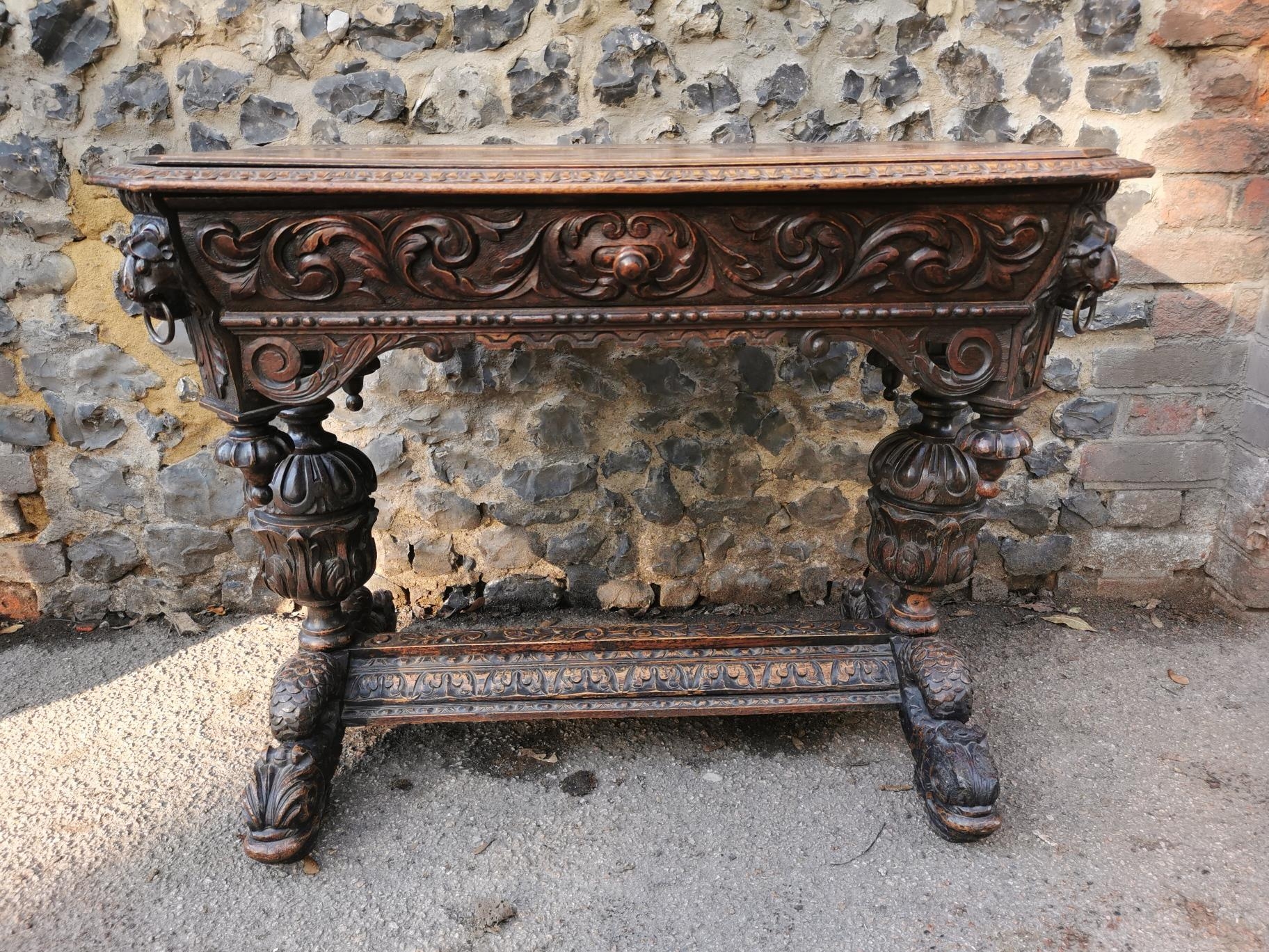 A 19th century Renaissance style carved oak library table, possibly French, with carved dolphin