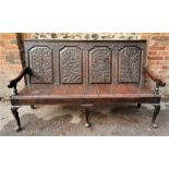 An 18th century carved oak box settle, with four floral carved back panels, raised on cabriole