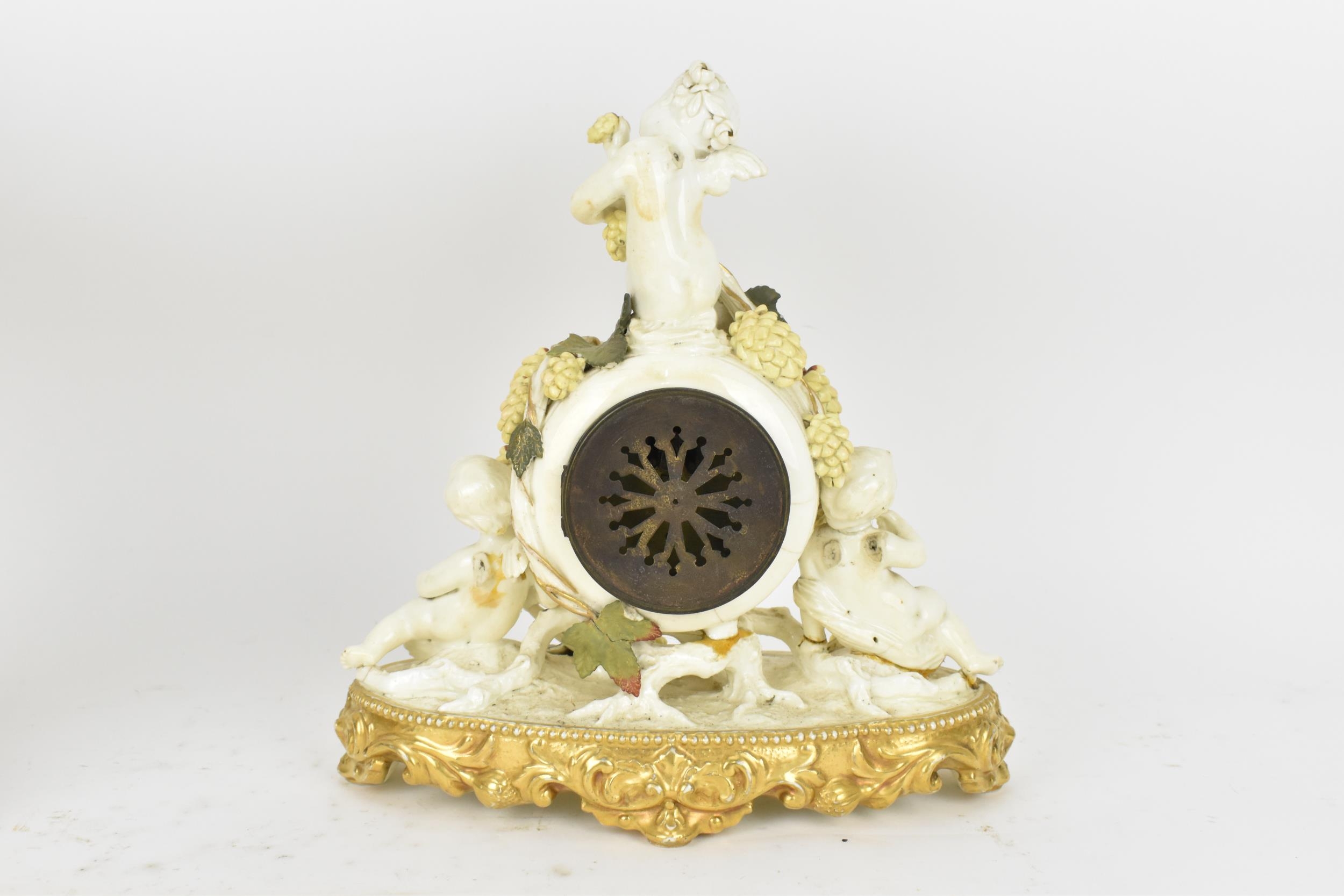 A late 19th century porcelain mantle clock, decorated with cherubs eating grapes on a gilded base, - Image 2 of 7