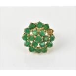 A 9ct yellow gold and emerald cluster dress ring, mounted with eighteen round cut emeralds, one