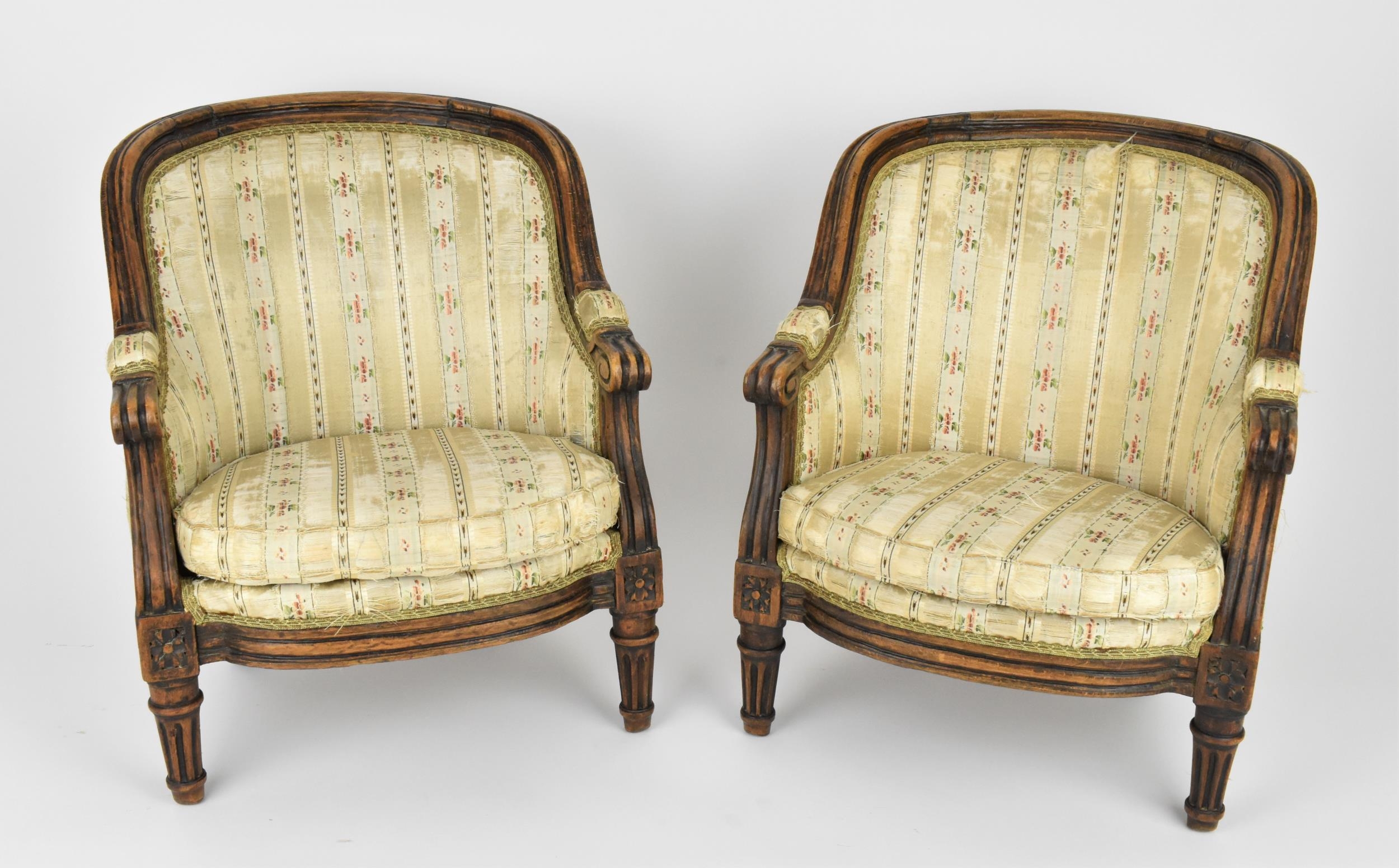 A pair of 18th century French Louis XVI bergère armchairs, circa 1780, with channelled mahogany