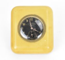 An early 20th century travel/bedside clock having a black dial, with gilt hands, Arabic numerals and