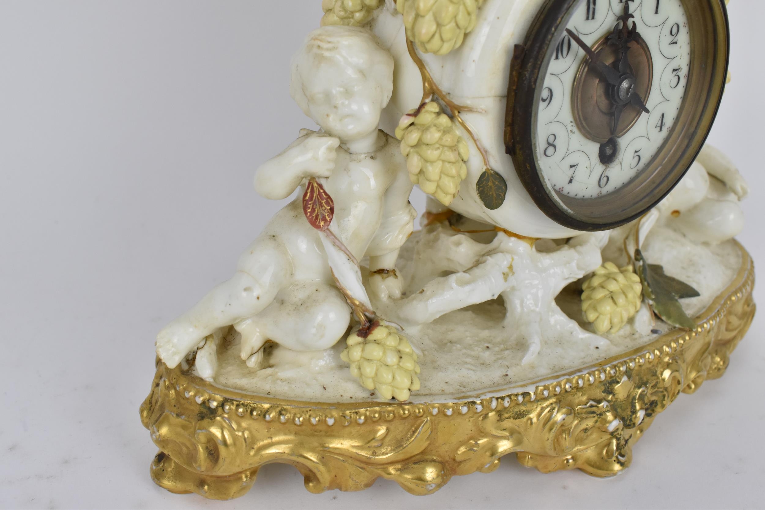 A late 19th century porcelain mantle clock, decorated with cherubs eating grapes on a gilded base, - Image 7 of 7