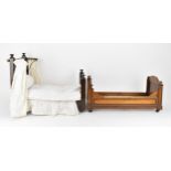 A Victorian doll's mahogany sleigh bed, with beaded mouldings, on casters, 27.5 cm high x 59.5 cm