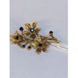 A gold brooch fashioned as a flower, set with sapphires, tested as 9ct, 4.8g Location: