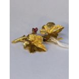 A 18ct gold brooch fashioned as two leaves set with rubies Location:
