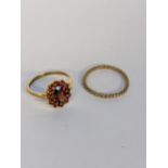 A 9ct gold cluster ring inset with a garnet, together with a yellow metal band, 1.25g Location: