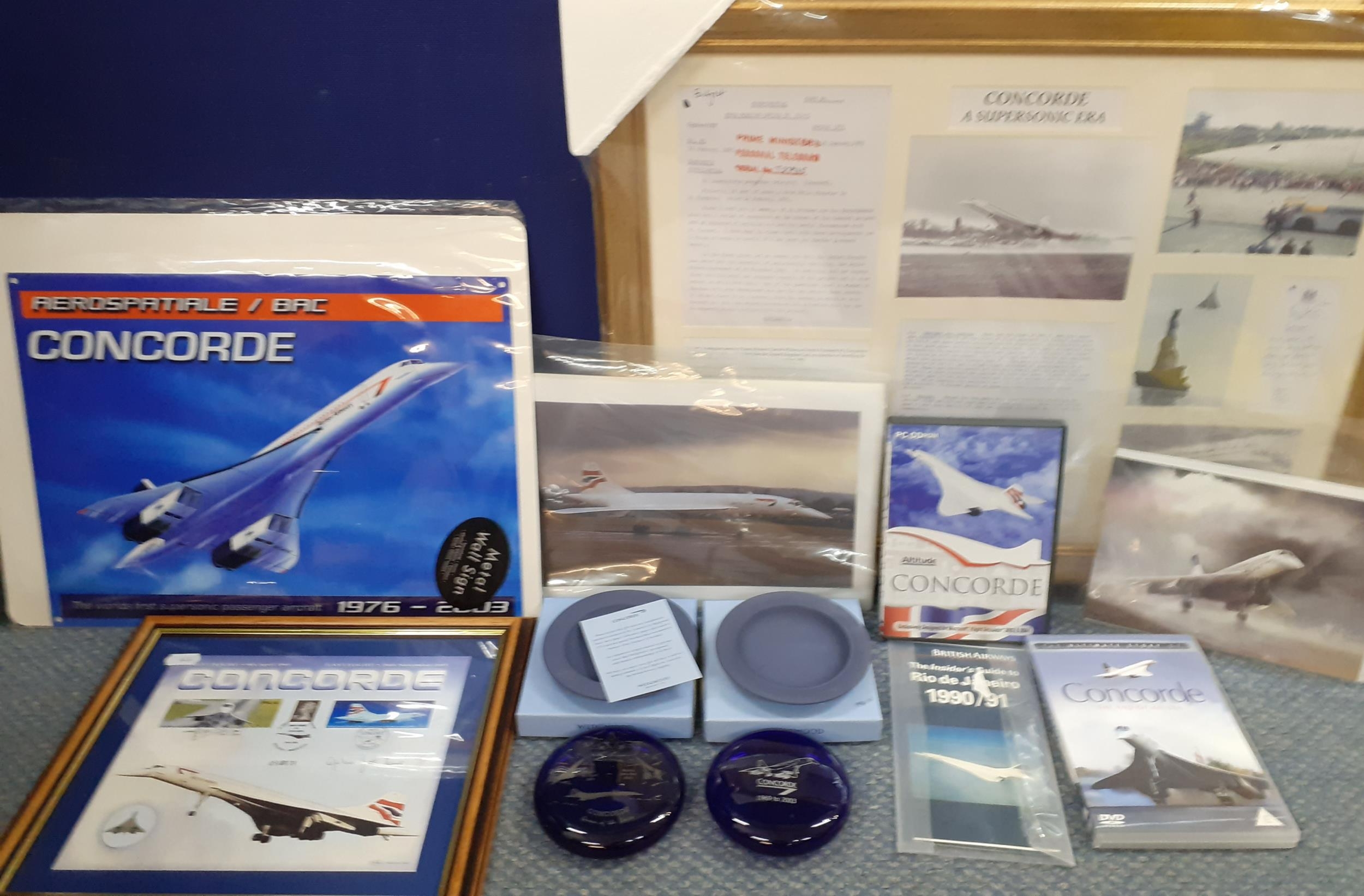 Concorde related items to include two blue glass paperweights, two Wedgwood dishes, DVD's and prints