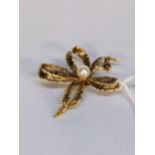 A 9ct gold brooch fashioned as a bow, set with a pearl, 4.9g Location: