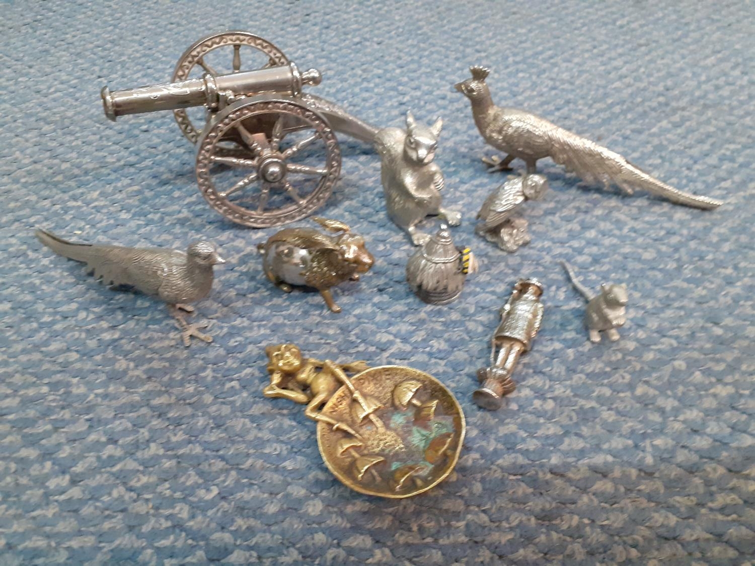 Silver coloured ornaments and trinkets to include models of animals, birds and a canon, together