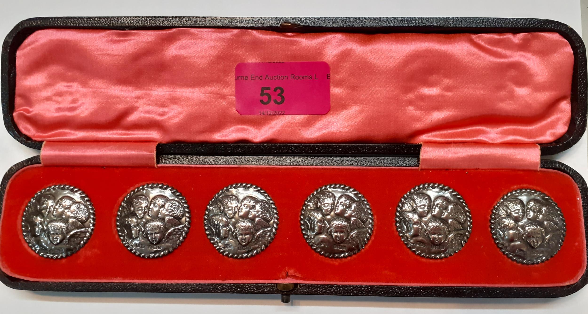 A cased set of 6 early 20th Century silver buttons 'The Cherub Choir' with rope twist border, makers