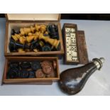 A boxed treen chess set, together with a set of bone dominos, drafts set and a powder flask