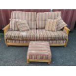 An Ercol light elm sofa with loose cushions and matching foot stool