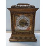 A late 19th/early 20th century oak cased mantel clock having a carved case with glass day movement