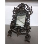 A small late 19th/early 20th century cast iron mirror with easel back, decorated with cherubs and