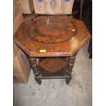 A late Victorian two tier occasional table, the octagonal top decorated with winged cherub heads