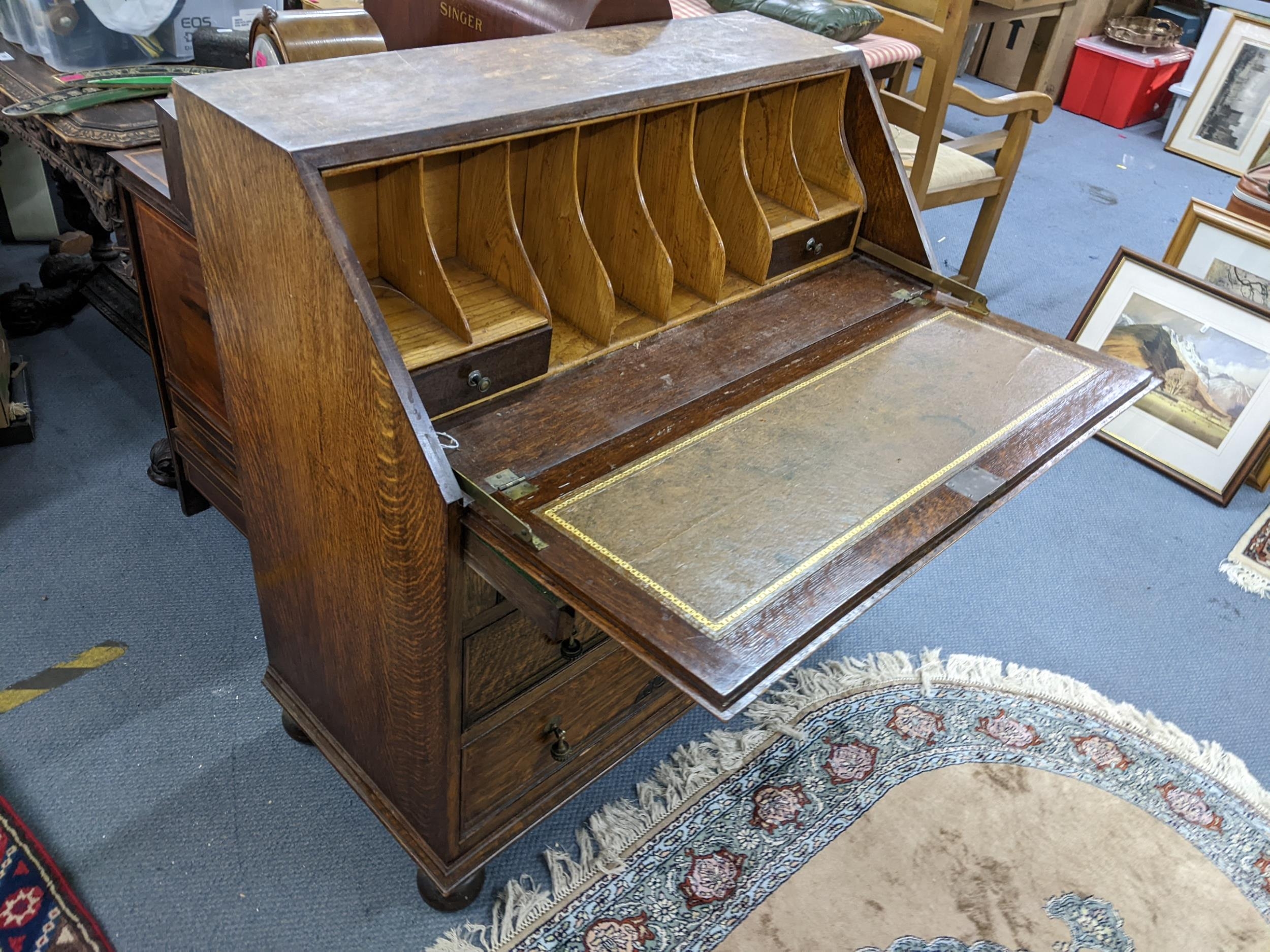 An early 20th century oak bureau having a fall flap with fitted interior above three long drawers - Image 2 of 2