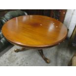 An early Victorian mahogany pedestal tilt top table, circular top with moulded edge, turned column