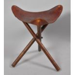 A Tooled Leather Topped Triangular Stool on Turned Tripod Supports