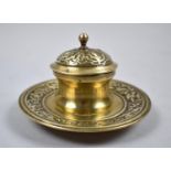 A Brass Desktop Inkwell with Glass Liner and Hinged Lid on Circular Tray with Decorated Border, 12cm