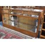 A Modern Shop Counter with Glazed Illuminated Shelved Display Area, Mirrored Base and Sliding Rear