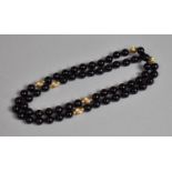 A Heavy Onyx and Yellow Metal Bead Necklace having Six Large Fluted Yellow Metal Beads and Twelve
