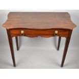 An Edwardian Mahogany Side Table with Single Long Drawer and Shaped Top on Tapering Square Supports,