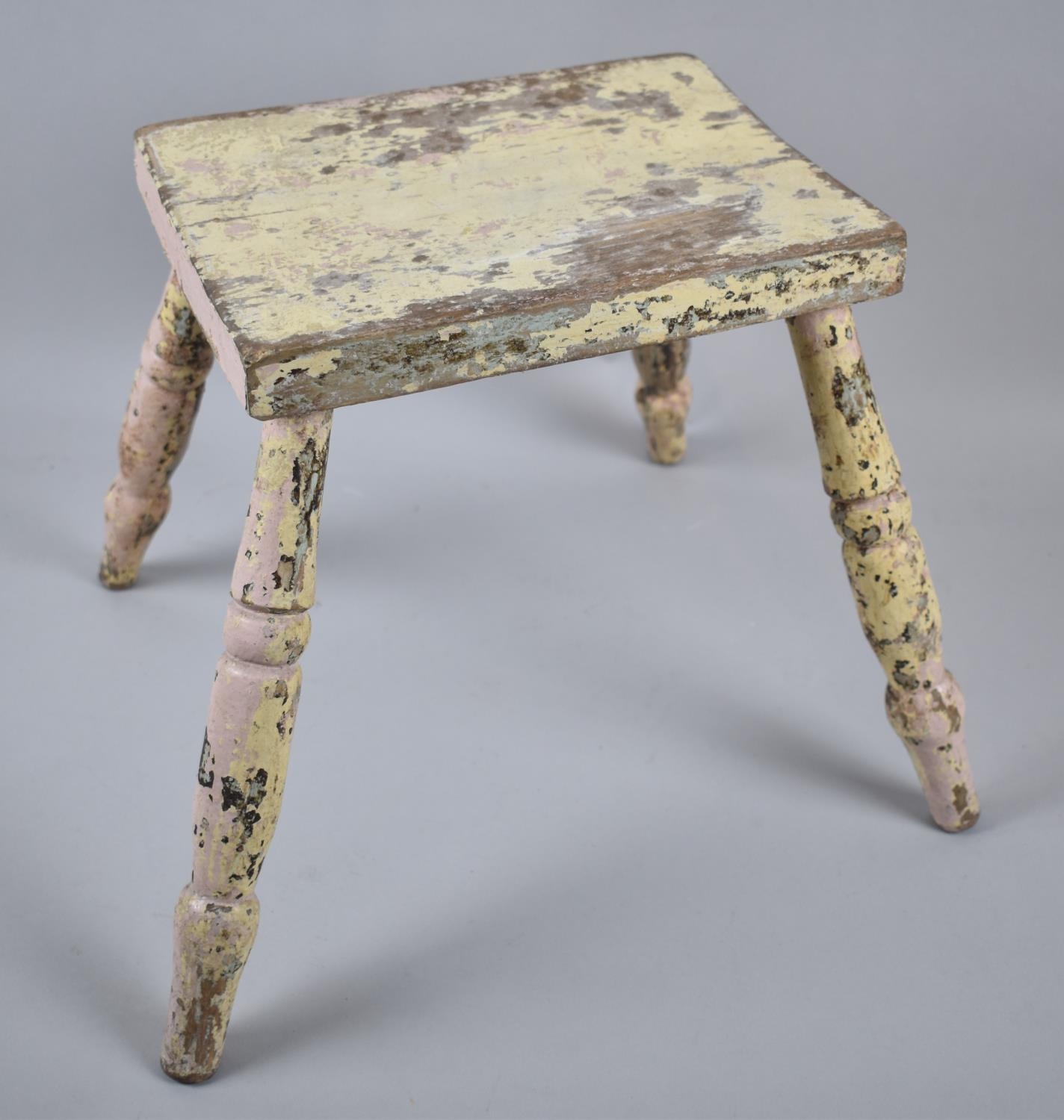 A Vintage Cream Painted Rectangular Topped Milking Stool on Four Turned Supports, 25cm Wide