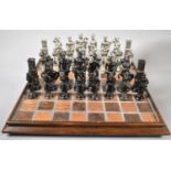 A Cast Metal Chess Set, the Kings 12.5cm high on Unrelated Wooden Chessboard, 42cm Square