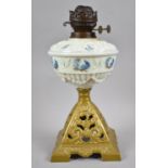 A Victorian Cast Iron Based Oil Lamp with Opaque Glass Relief Decorated Reservoir, Duplex