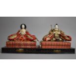 A Pair of Japanese Hina "Emperor and Empress" Dolls Each Seated on a Woven Plinth Set on Ebonised