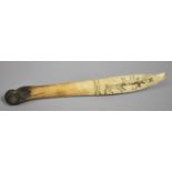 A North American Inuit Carved Bone Hunting Knife decorated with Scrimshaw Reindeer. 24.5cms Long
